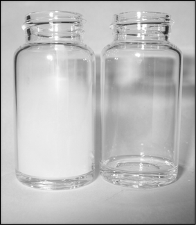 Visual comparison of triflic acid (left vial, 1 g) to TFESA (right vial, 1 g) in air after 1 min.